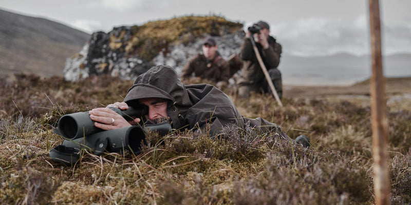 Stalker in layered kit on open hillside